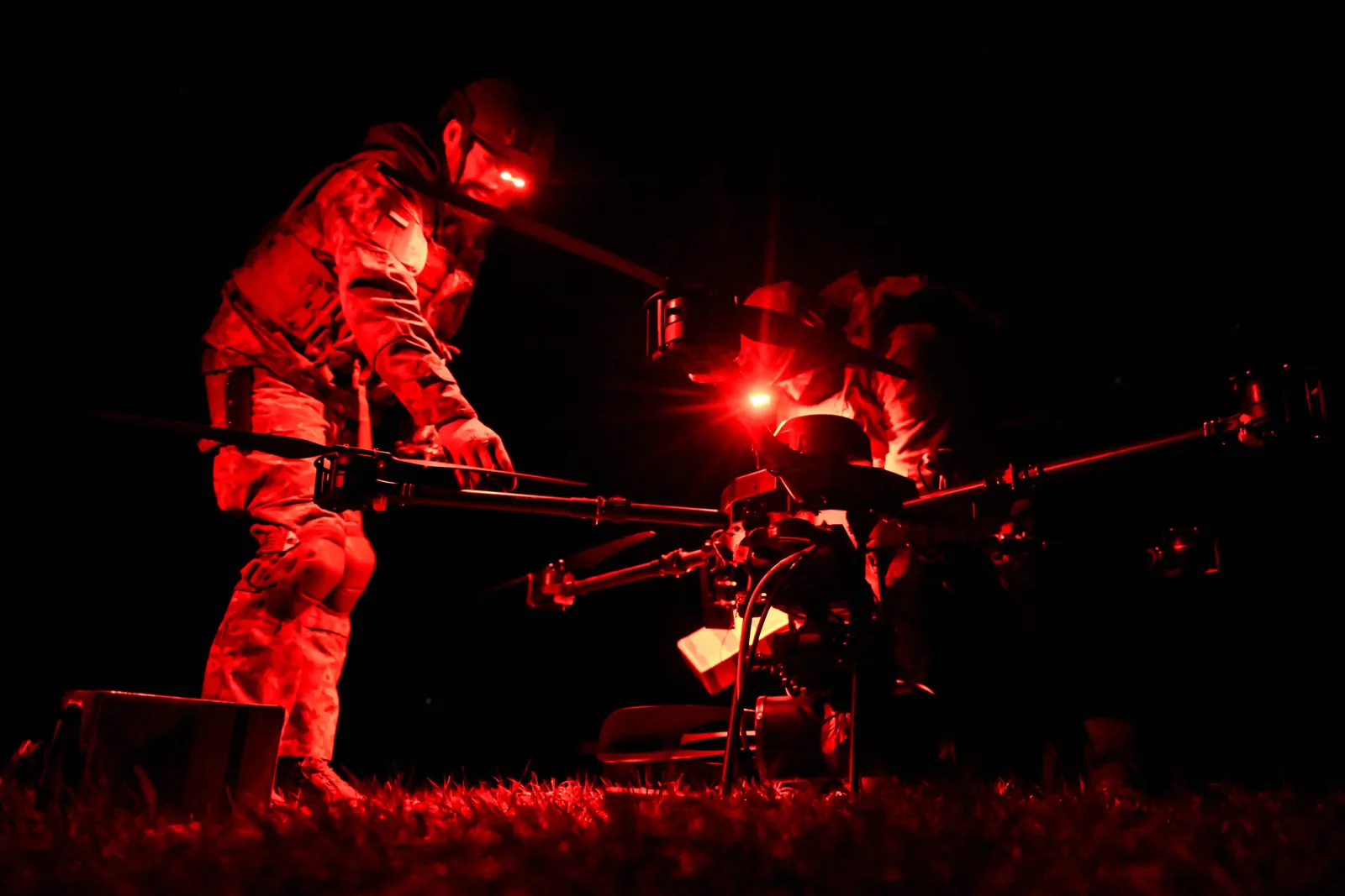 UAV crew operating equipment at night under infrared illumination